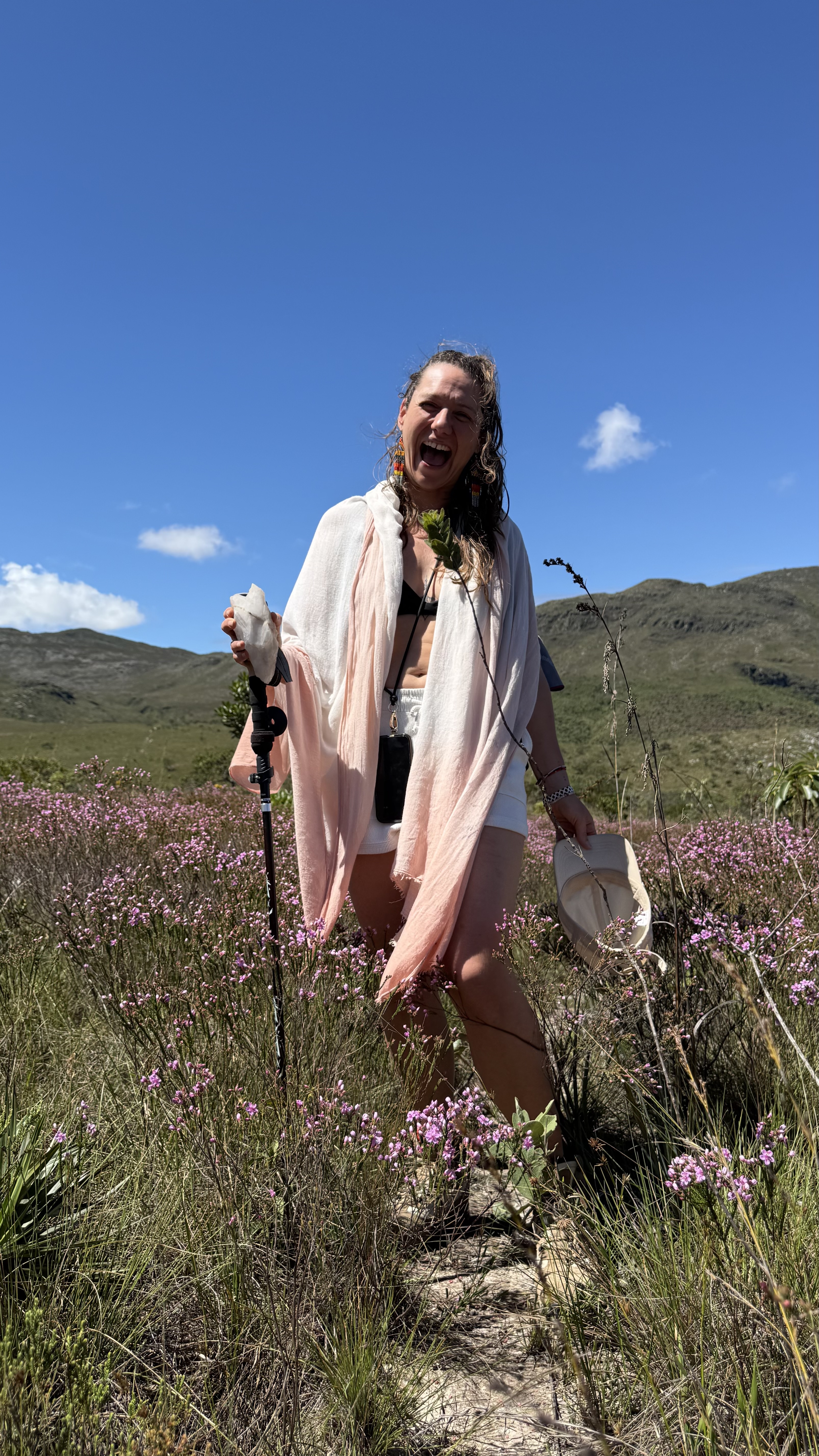 Janina lacht herzlich in einem Feld mit pinken Blumen