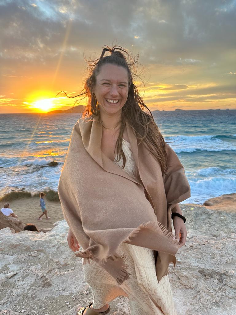 Janina lächelt am Meer im Sonnenuntergang